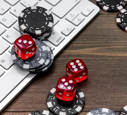 Casino chips and red dice resting on a computer keyboard